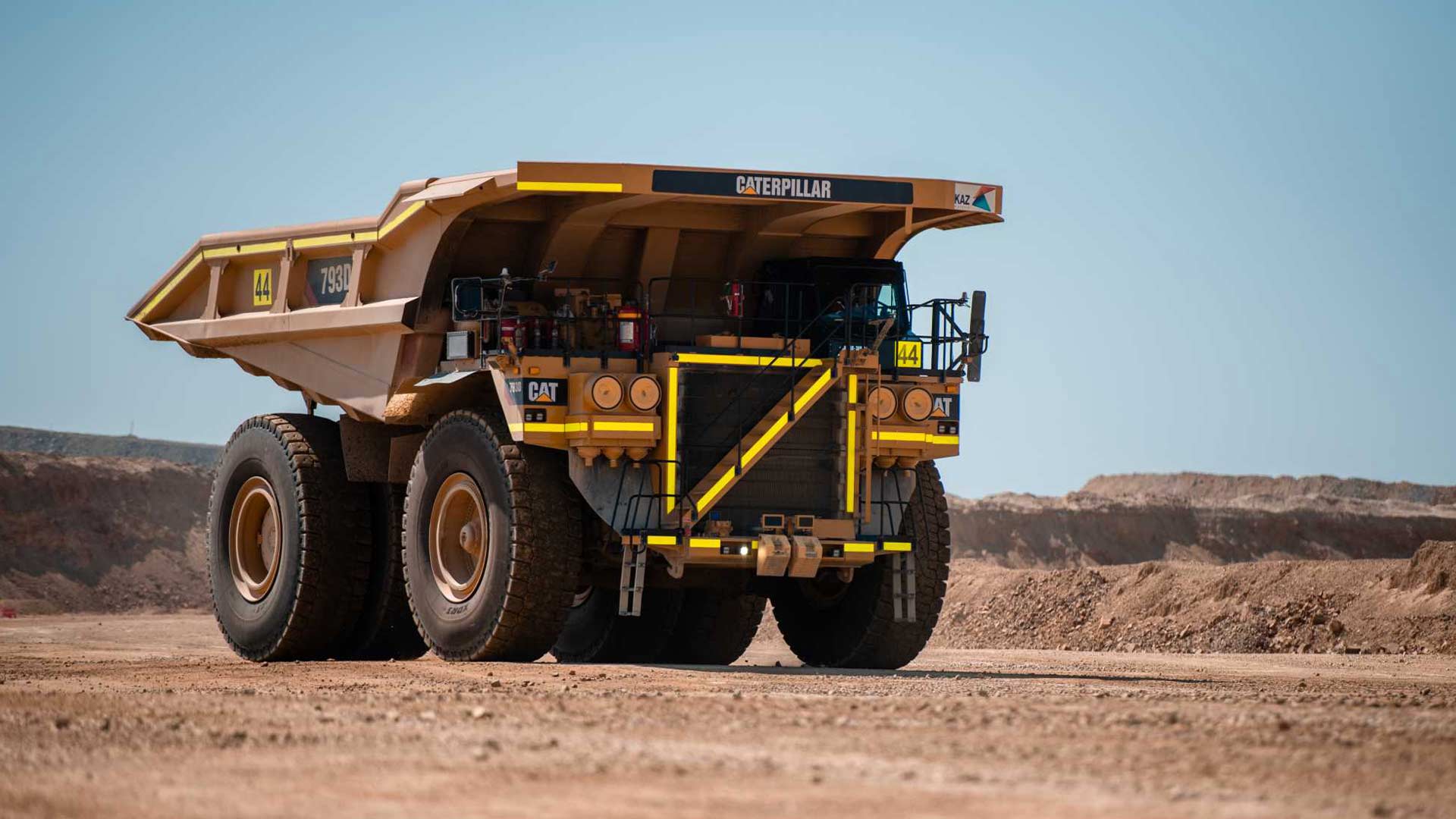 Mining truck set against a desert-like environment, with blue skies in the background. 