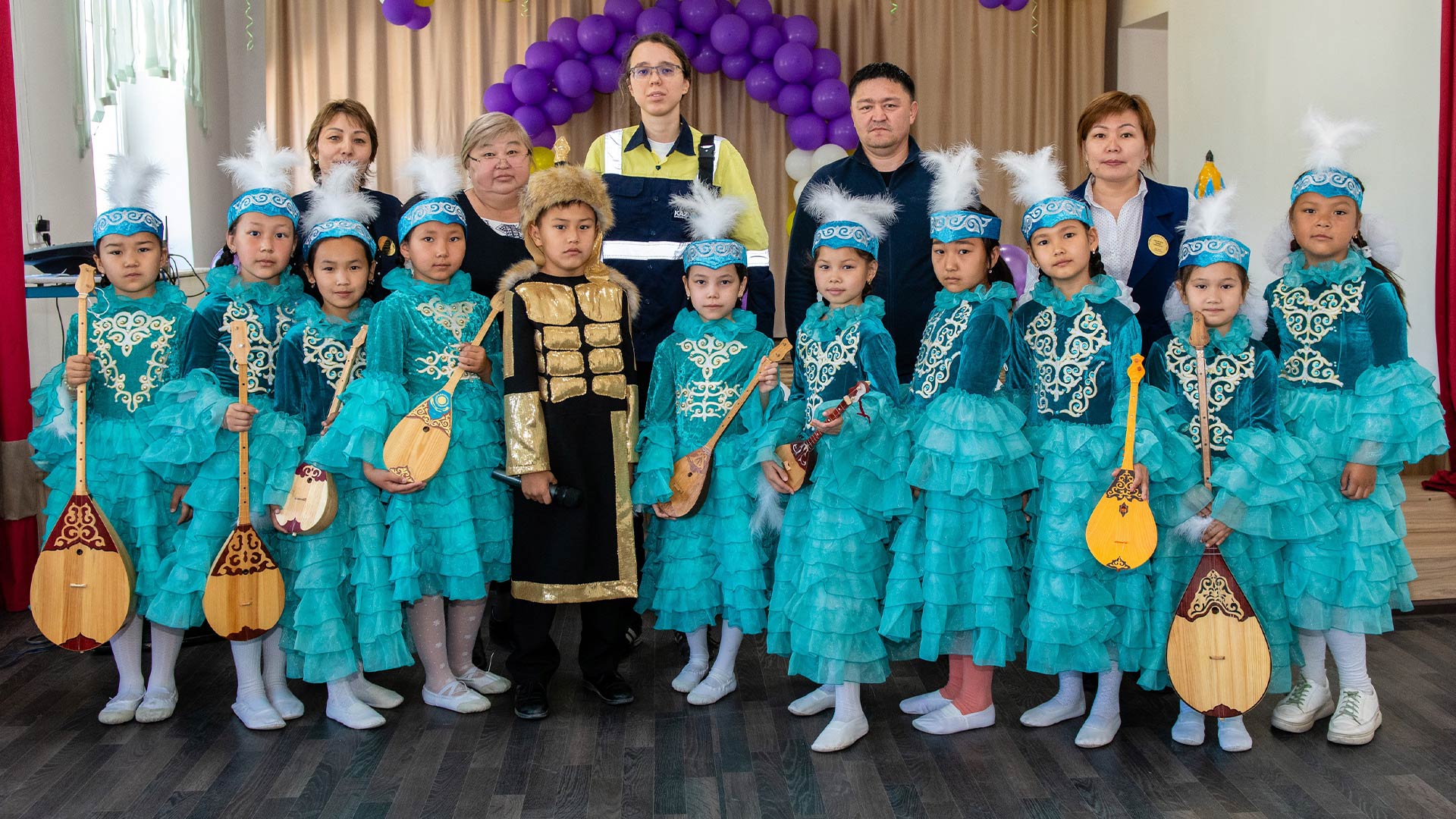 Children in matching turquoise gowns gathered to pose for a photo.