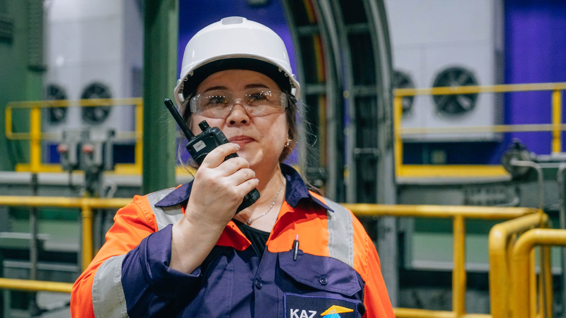 KAZ Minerals worker in safety gear using a two way radio device. 